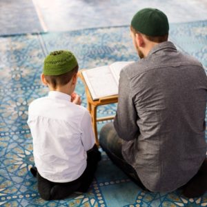 a father helps his son to memorize quran